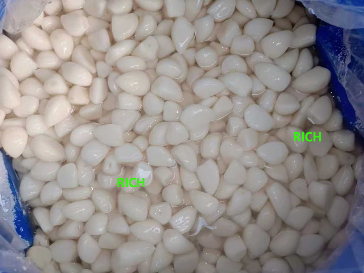 Peeled white garlic cloves in salted water